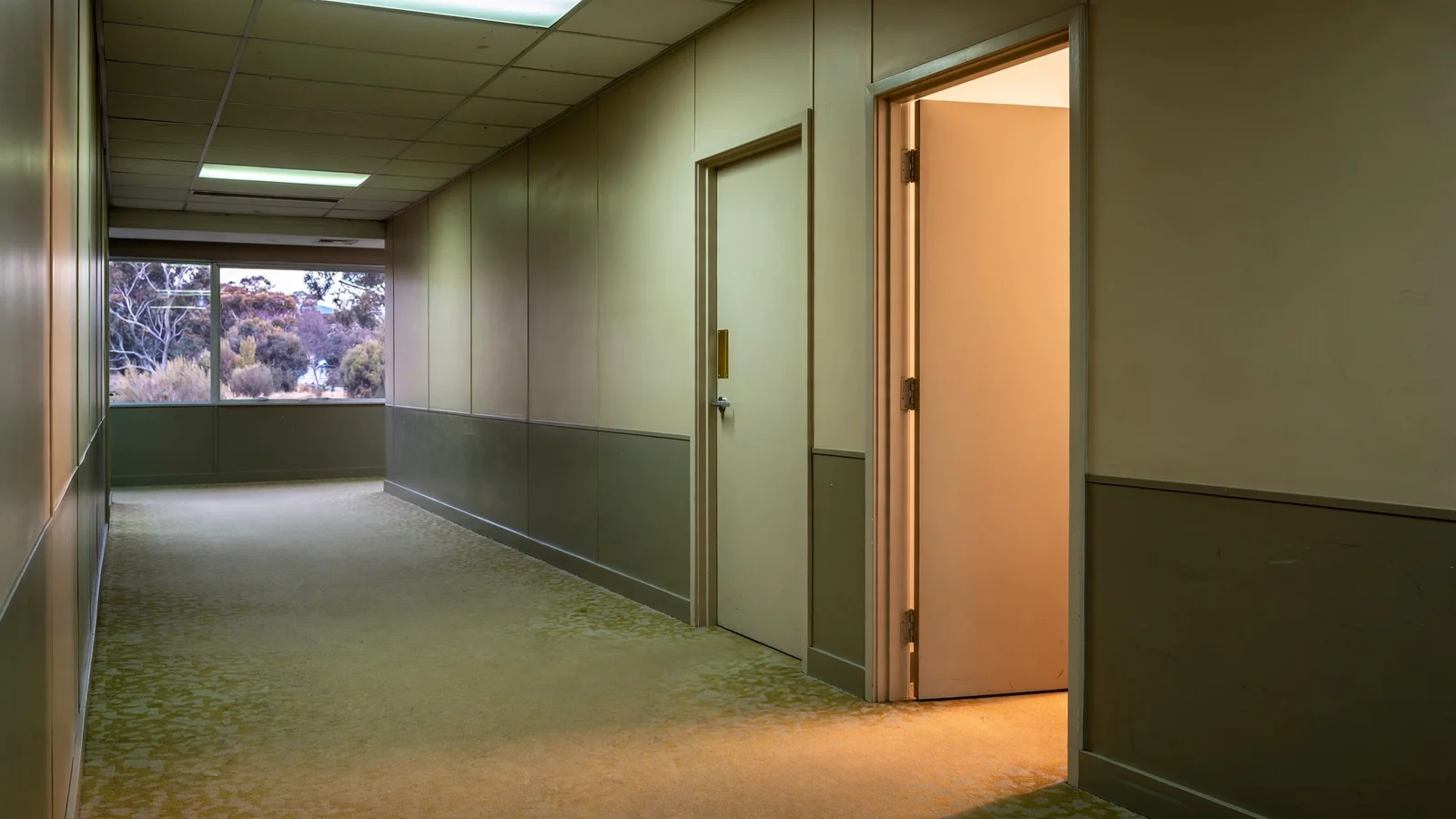 Office corridor with one open door and one closed door side by side
